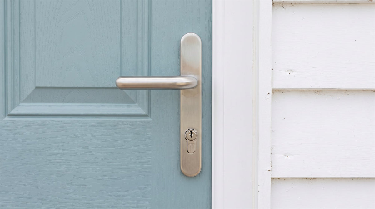 Brushed 316 stainless steel lever handle with euro cylinder on a duck-egg blue composite front door