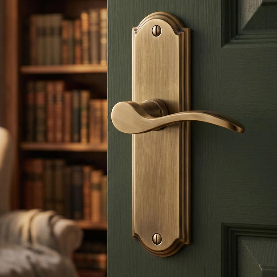 Antique brass lever handle on a green panelled door