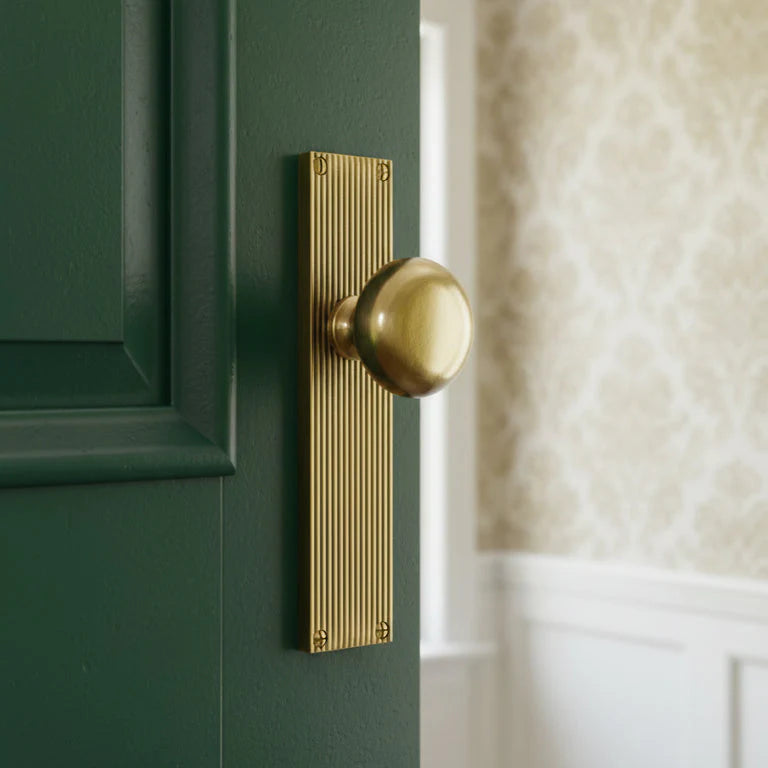Antique brass door knob on a green door