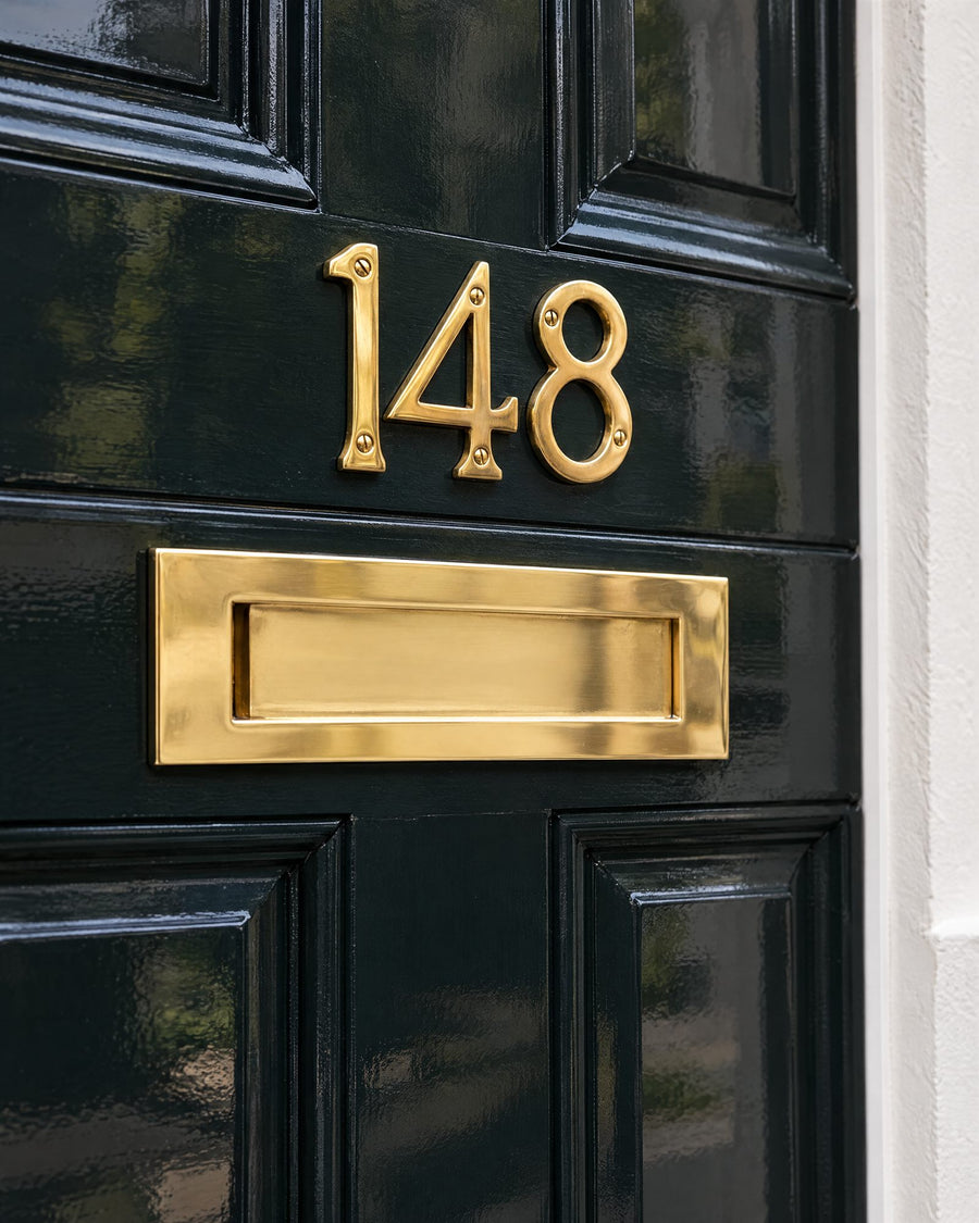 Polished brass door numbers above a plain polished brass letter plate