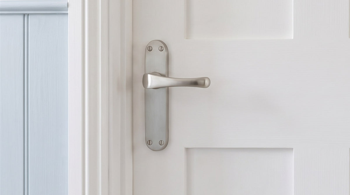Gloucester satin nickel lever handle on a white Shaker door beside powder blue tongue-and-groove panelling
