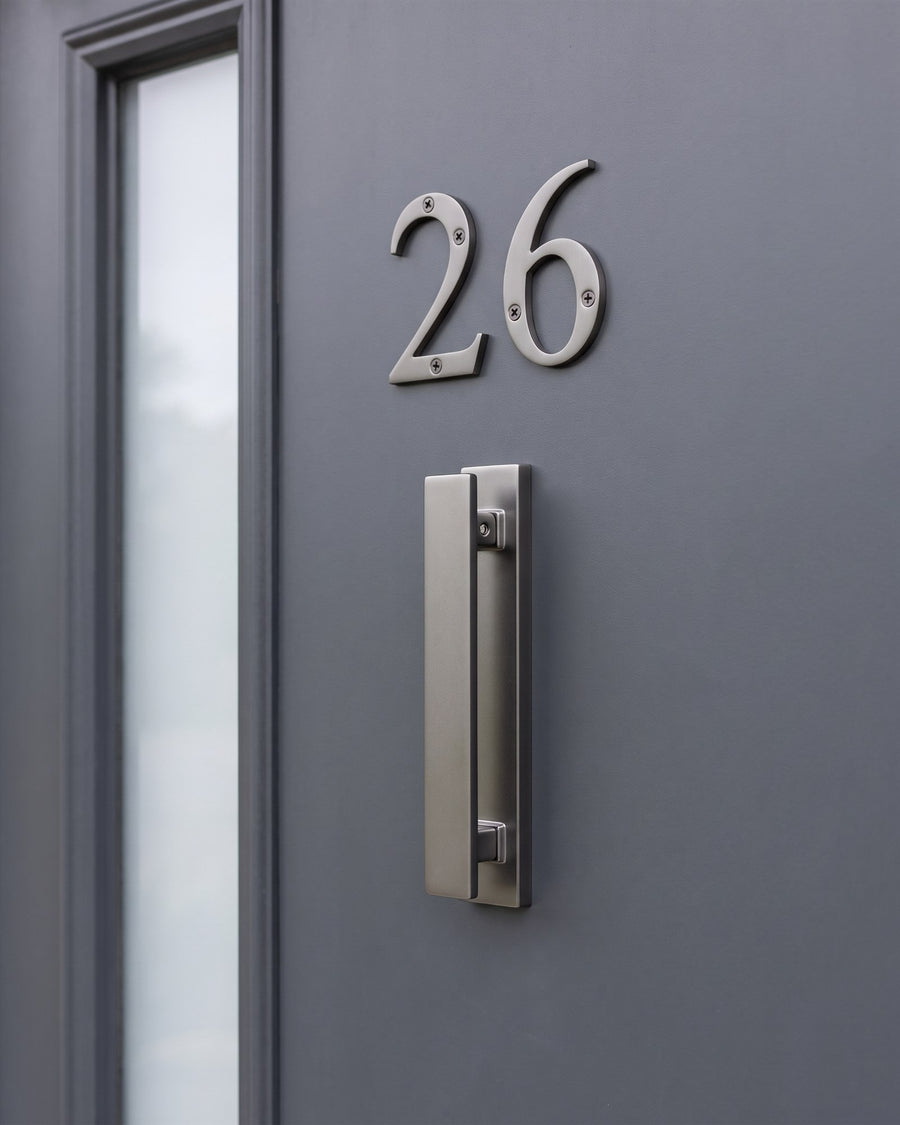 Graphite architectural bar knocker below serif graphite numbers 26 on an anthracite composite door beside a frosted glass strip