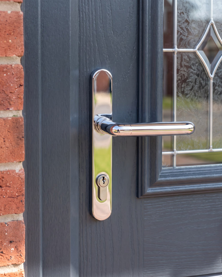 Hardex chrome Balmoral lever with a straight round-bar handle on a long rounded backplate with a euro cylinder, on an anthracite woodgrain composite door