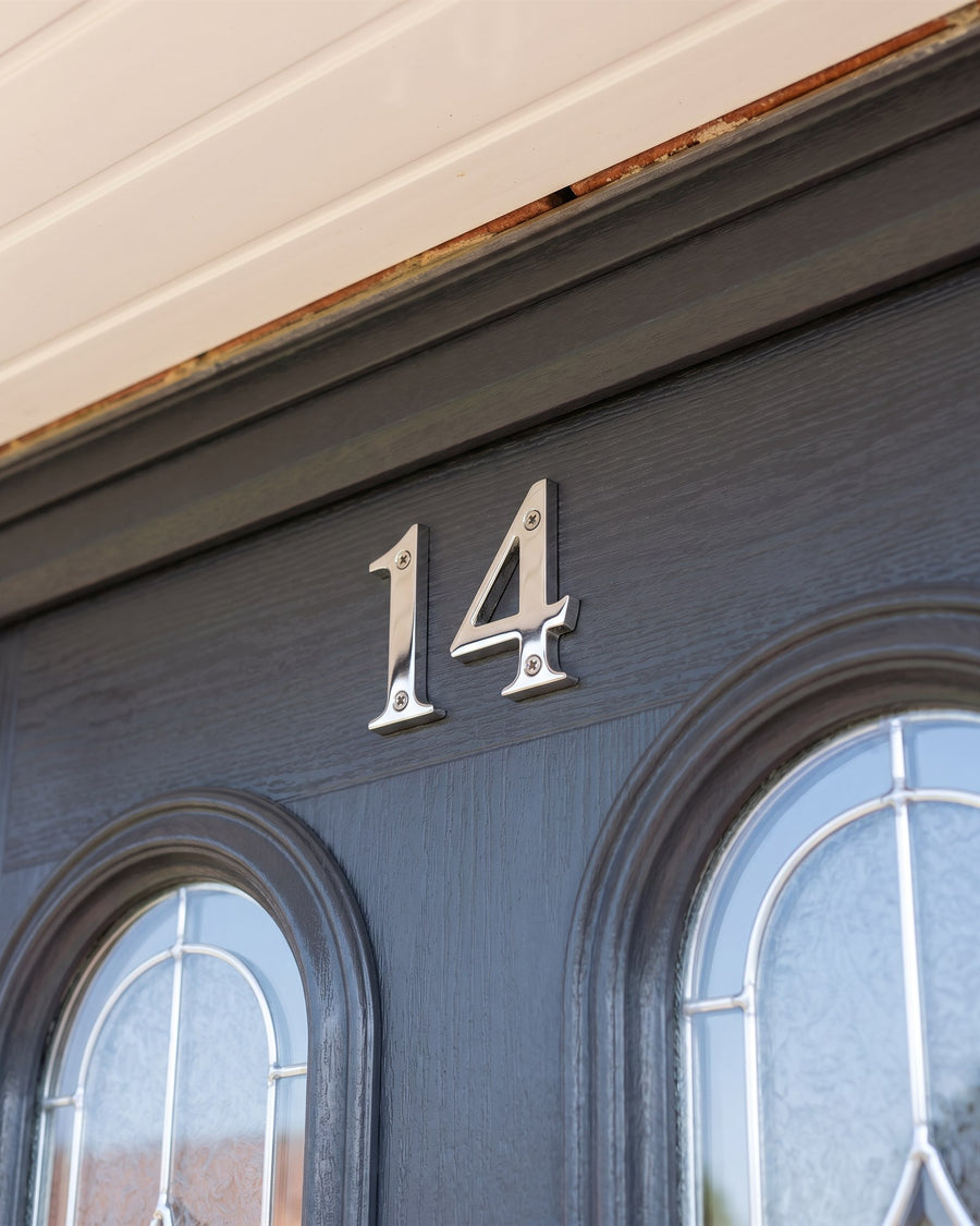 Hardex chrome serif numbers 14 on the top rail of an anthracite composite door above two arched leaded glass panels