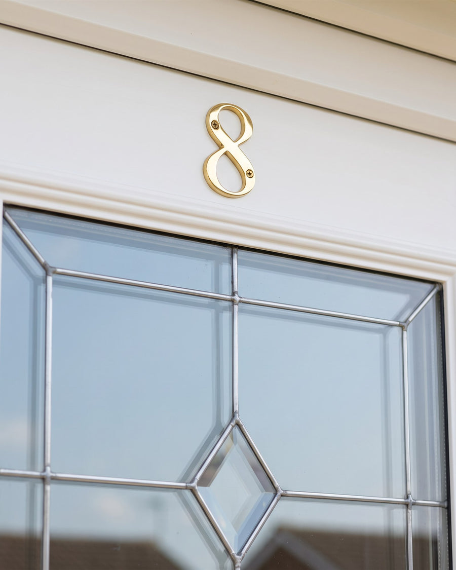 Hardex gold serif number 8 above a bevelled leaded glass panel on a white uPVC door