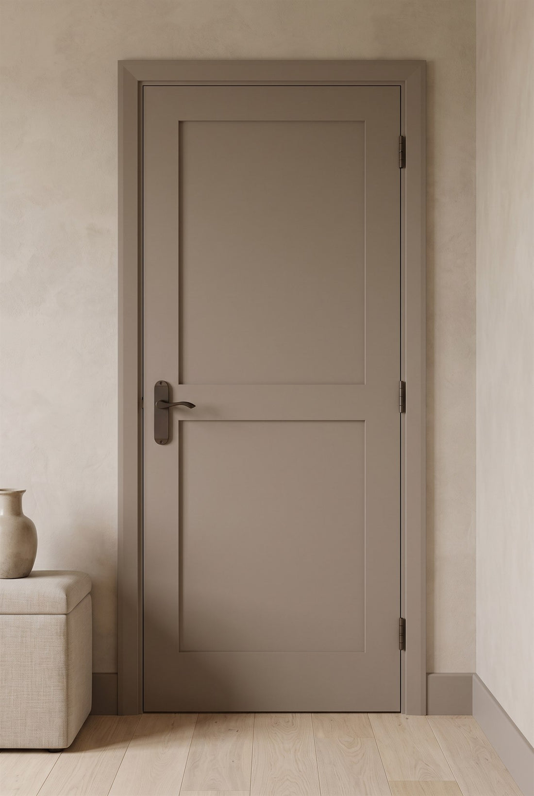 Mushroom-painted two-panel Shaker door with a matt bronze Algarve lever handle and matt bronze butt hinges in a limewashed hallway