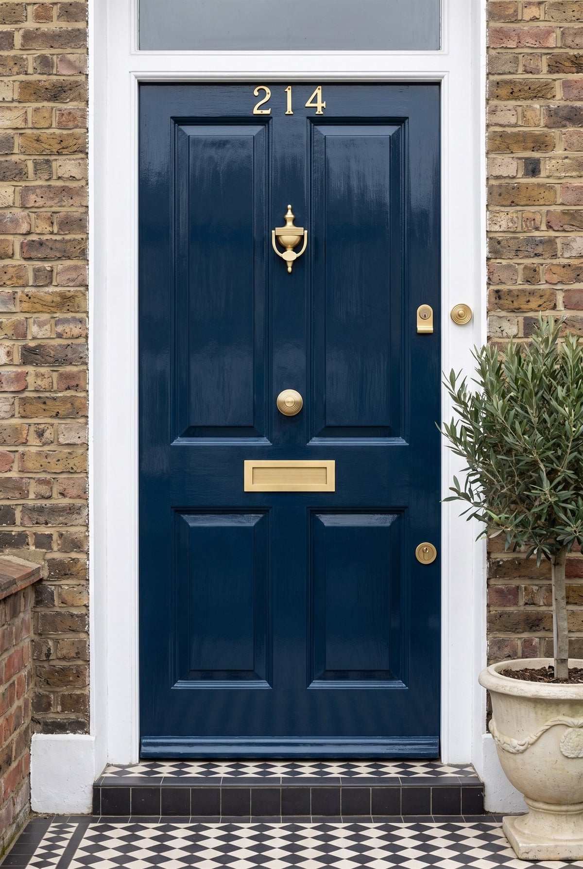 Navy front door with reeded satin brass knob, knocker and letter plate