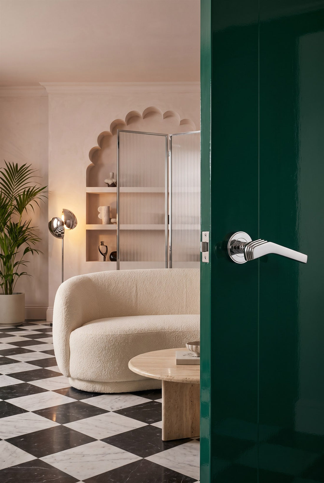 NeoDeco living space with a curved boucle sofa, marble chequerboard floor, fluted glass screen and scalloped arch, and a high-gloss emerald door with a polished chrome Tiffany Art Deco lever