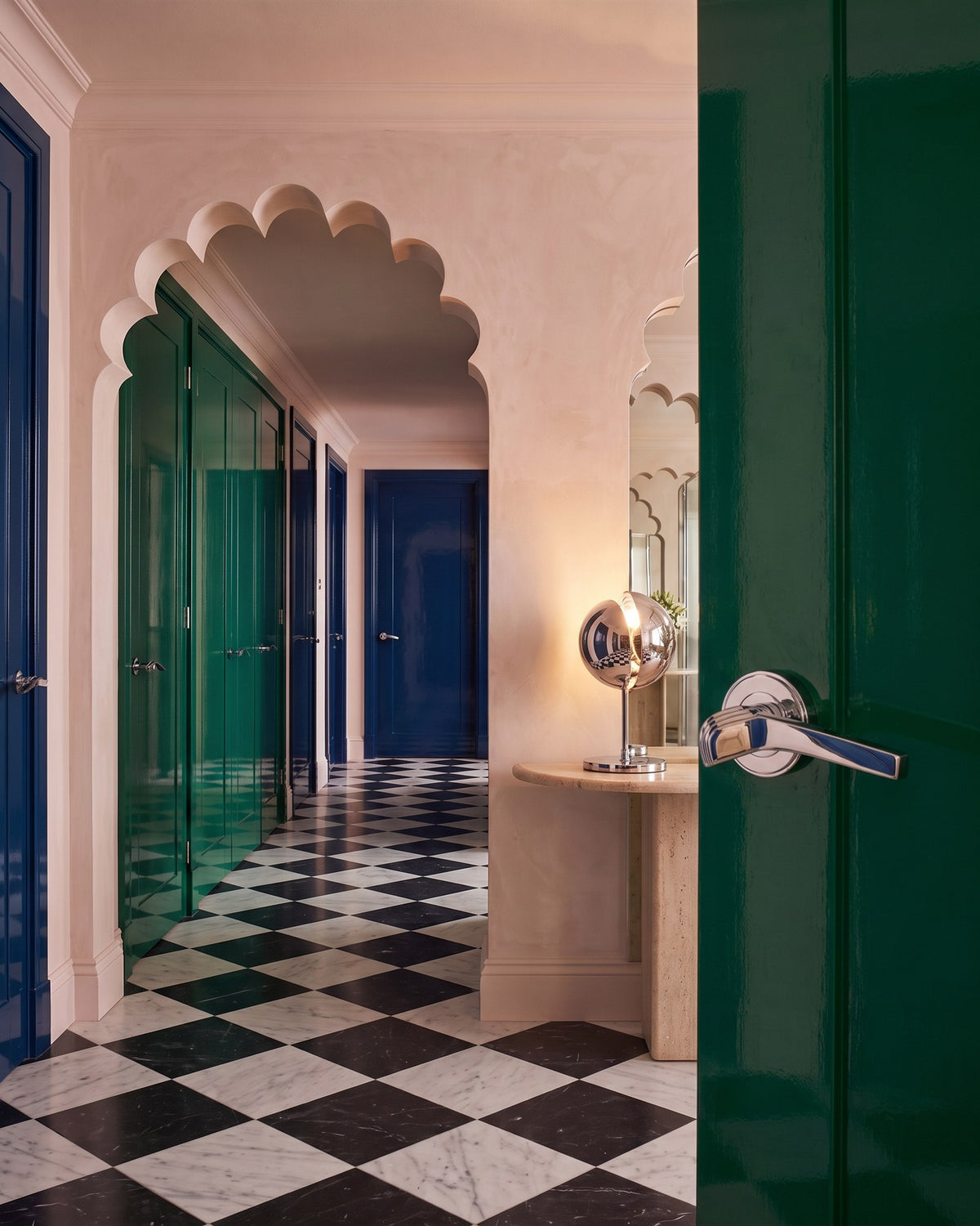 NeoDeco hall with scalloped arches and a marble chequerboard floor, seen past a glossy green door with a polished chrome Tiffany lever