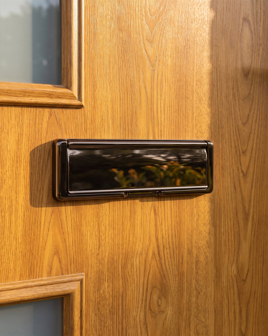 Hardex bronze Nu Mail shield letter plate on a golden oak woodgrain composite door