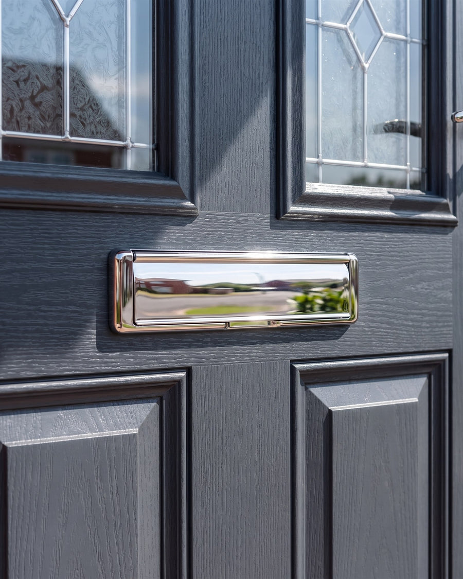 Nu Mail Hardex chrome shield letter plate on the middle rail of an anthracite composite door below arched leaded glass
