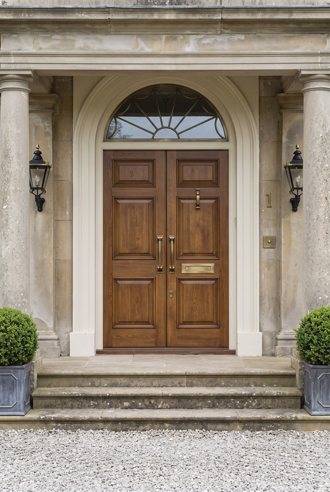 Stained oak double front doors under a semicircular fanlight in a stone portico, with mirrored antique brass cranked pulls, a doctor knocker, letter plate, covered escutcheon, square bell push and house number