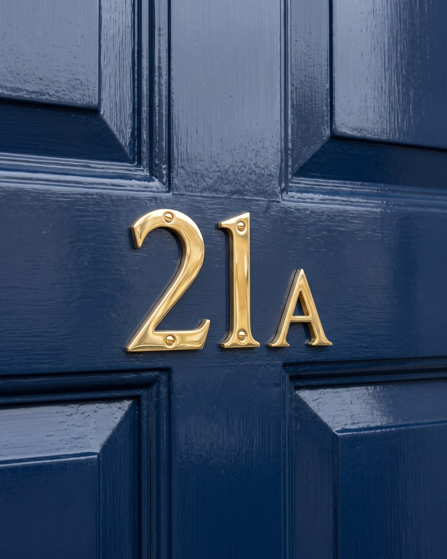 Polished brass number 21 with a smaller polished brass letter A on a glossy navy panelled door