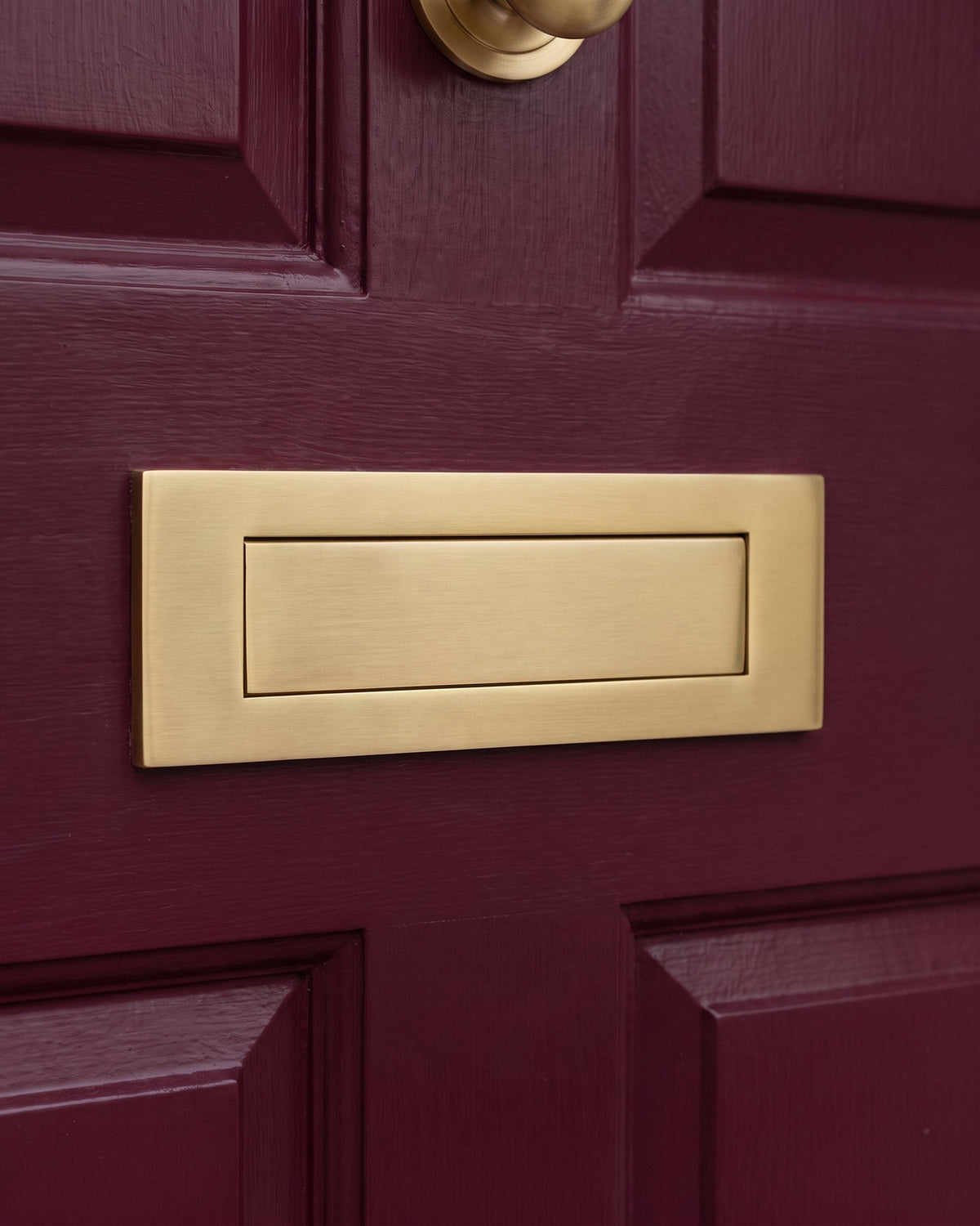 Satin brass letter plate on a burgundy front door