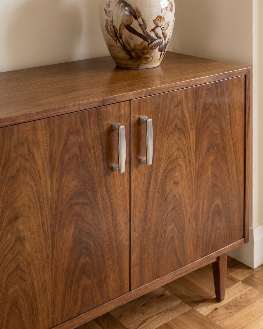 Satin chrome Art Deco cabinet pull handles on a figured walnut sideboard