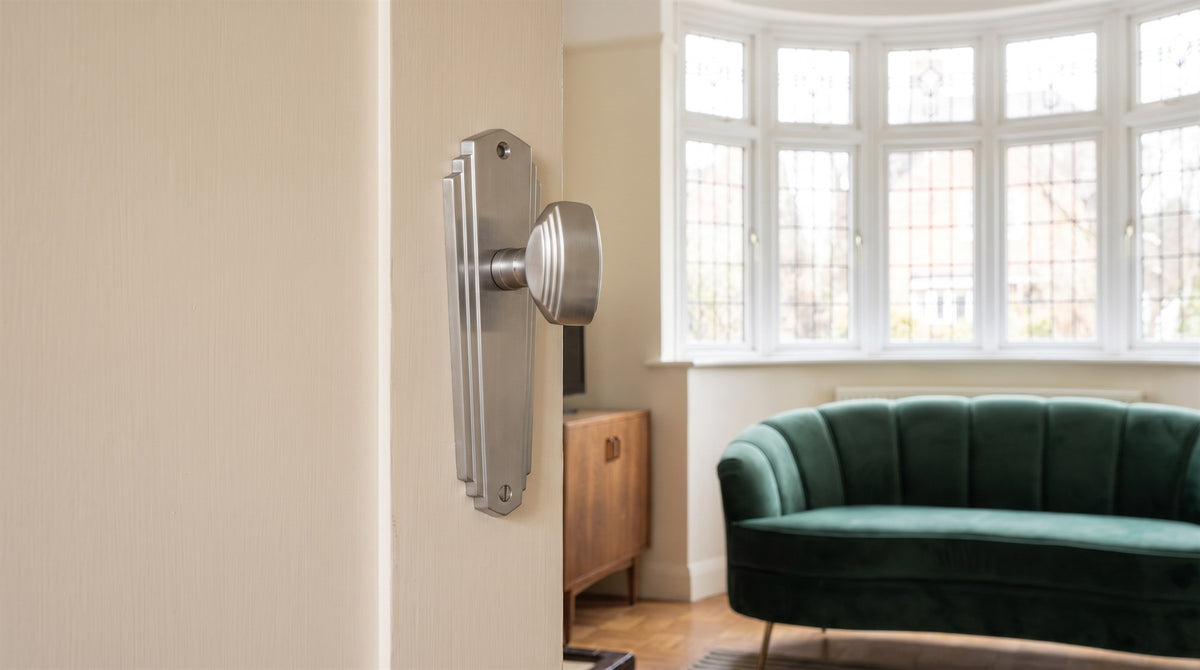 Satin chrome Art Deco knob on a long stepped backplate on a cream 1930s door