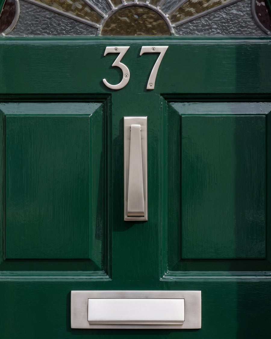 Satin nickel house numbers, slim knocker and letter plate on a green gloss 1930s front door below the sunburst glass