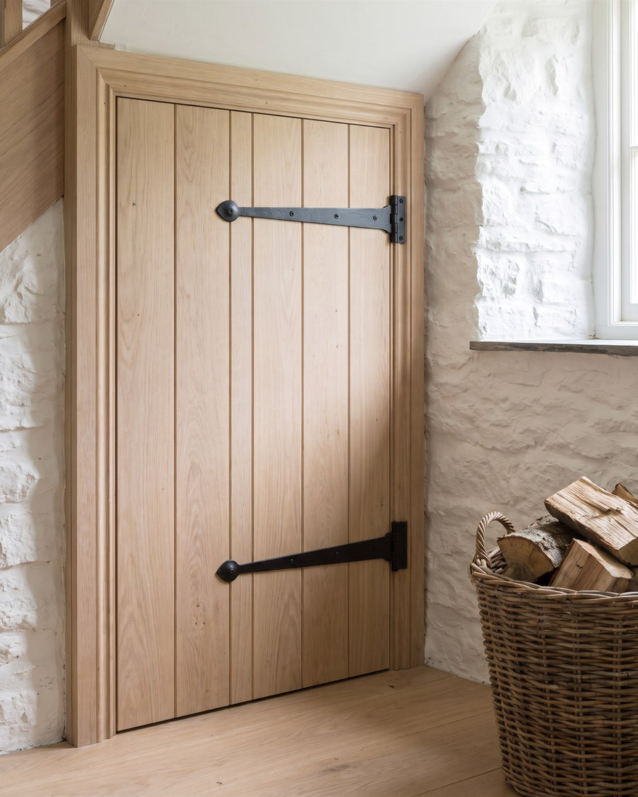Smooth black iron tee hinges on a pale oak ledged and braced understairs cupboard door