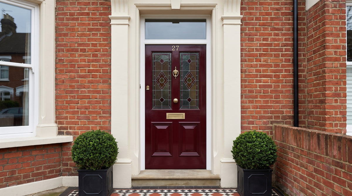 Oxblood Victorian front door with antique brass knocker, knob and letter plate